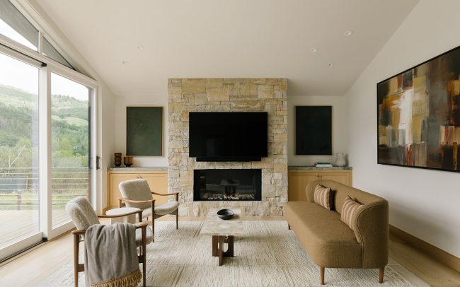 West Aspen Retreat living room with a stone fireplace and contemporary furnishings.