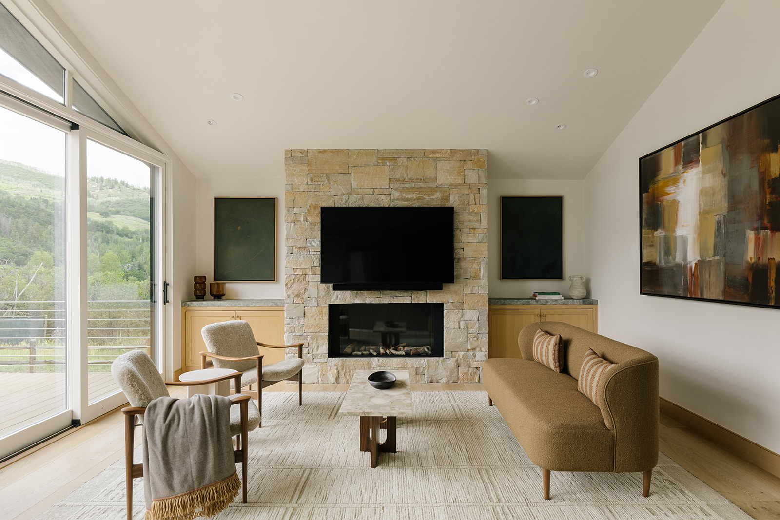 West Aspen Retreat living room with a stone fireplace and contemporary furnishings.